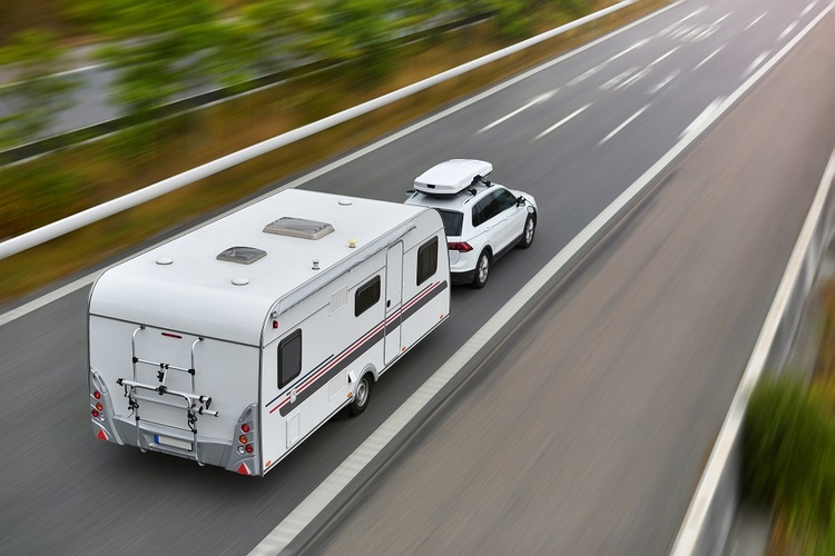 Car pulling camper trailer on road