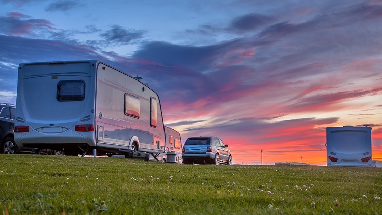 Campers and cars parked at sunset