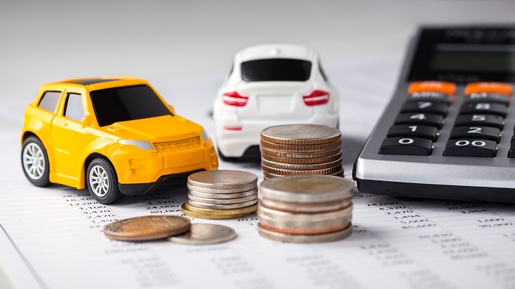 Toy cars next to calculator and coins